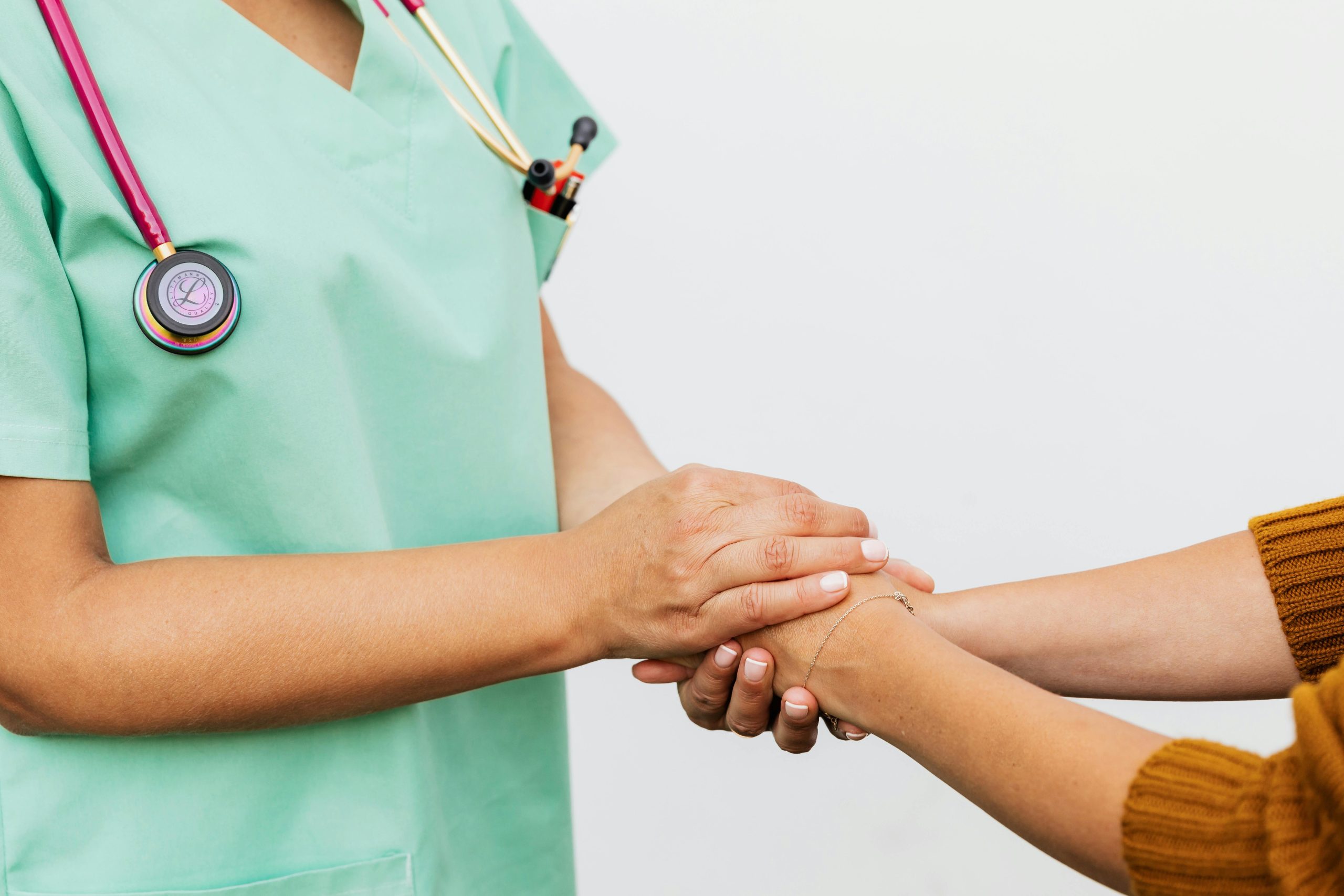 Close-up of a doctor holding a patient's hands, symbolizing trust and empathy in healthcare.